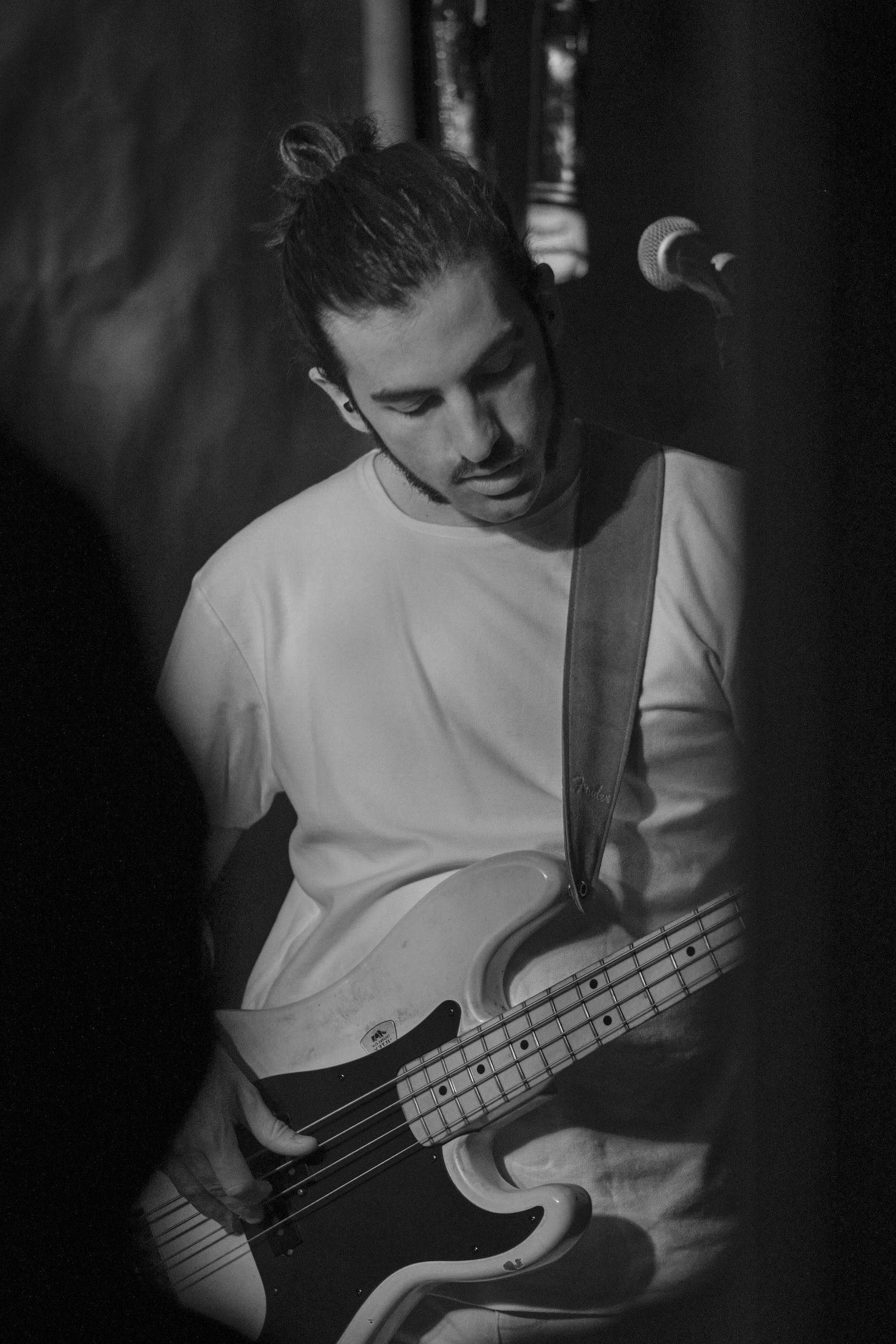 a black and white photography of Benedict playing his 1978 Fender Precision Bass live in concert